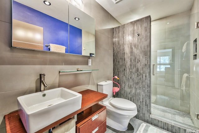 bathroom with toilet, an enclosed shower, sink, and tile walls