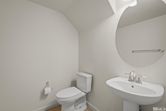 bathroom with sink, vaulted ceiling, and toilet