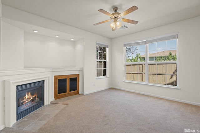 unfurnished living room featuring ceiling fan and light colored carpet