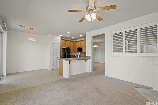 kitchen with black refrigerator with ice dispenser, hanging light fixtures, kitchen peninsula, light colored carpet, and a breakfast bar area