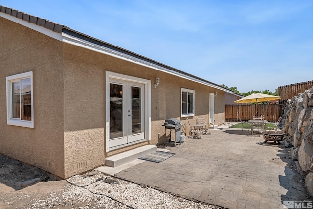 view of patio featuring french doors, area for grilling, and a fire pit