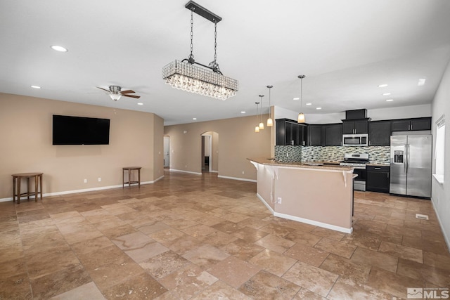 kitchen with decorative light fixtures, tasteful backsplash, a kitchen bar, ceiling fan, and stainless steel appliances