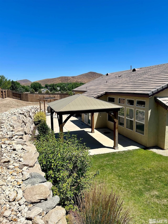 back of house with a patio area, a lawn, a mountain view, and a gazebo