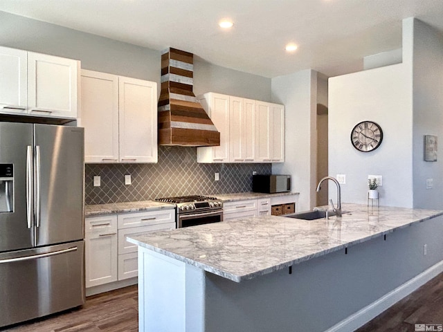 kitchen featuring backsplash, dark hardwood / wood-style flooring, stainless steel appliances, wall chimney exhaust hood, and sink