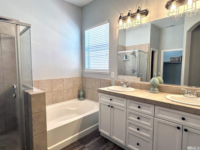 bathroom featuring dual vanity, shower with separate bathtub, and hardwood / wood-style flooring