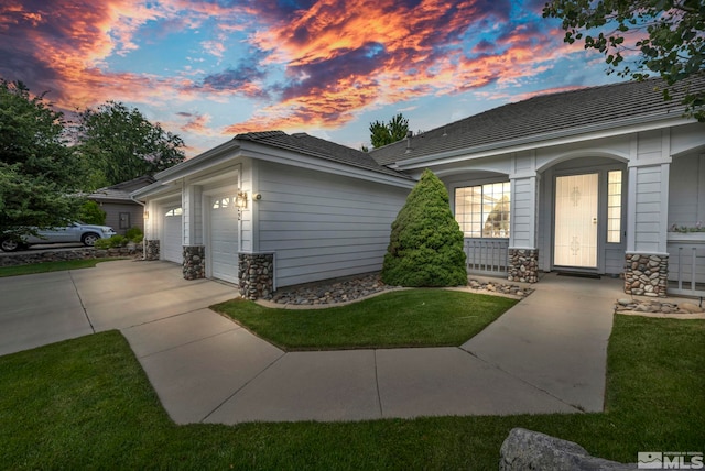 single story home with a garage and a lawn