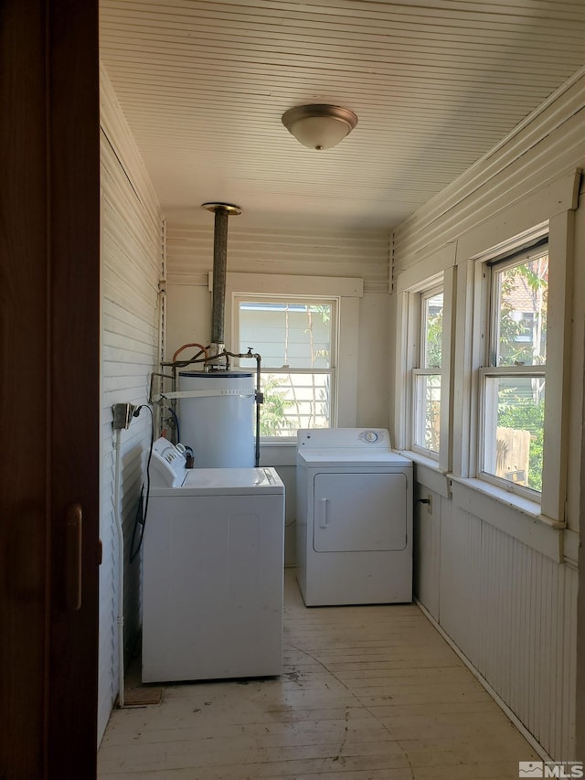 laundry room featuring washer and dryer, light hardwood / wood-style flooring, and water heater