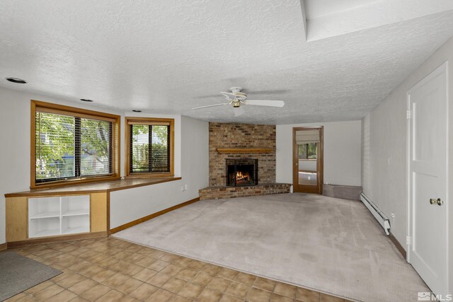 unfurnished living room with a fireplace, light carpet, a baseboard radiator, and a textured ceiling