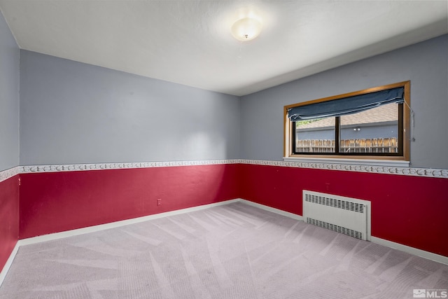 carpeted spare room featuring radiator