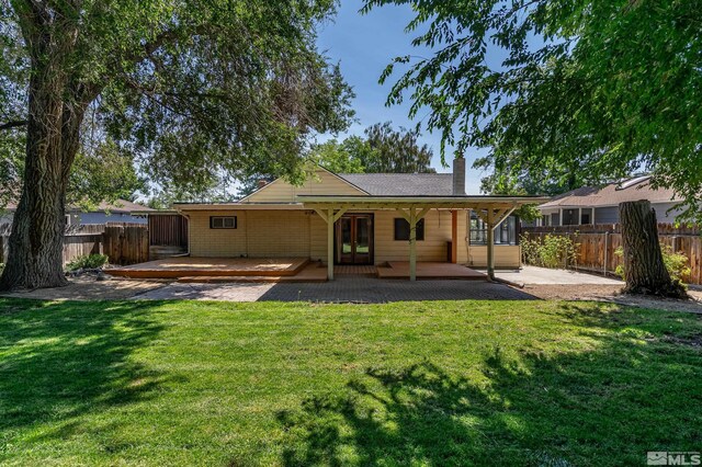 rear view of house with a yard and a patio area