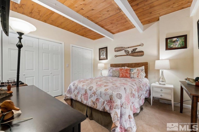 carpeted bedroom with wood ceiling, multiple closets, and beamed ceiling