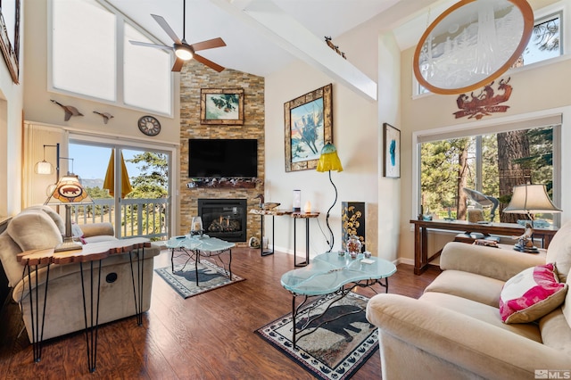 living room with dark hardwood / wood-style flooring, ceiling fan, a fireplace, and high vaulted ceiling