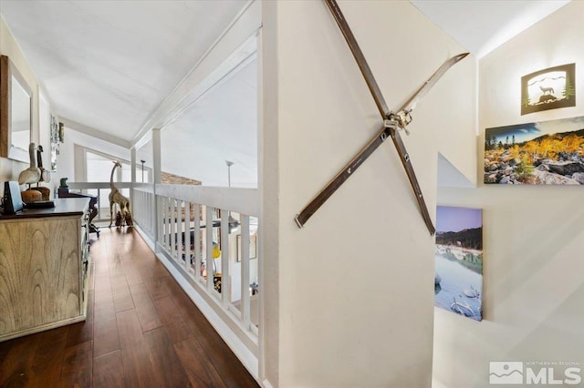 hallway with dark wood-type flooring and vaulted ceiling