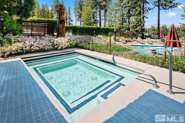 view of pool with a patio and an in ground hot tub