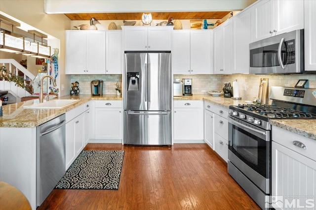 kitchen featuring sink, dark wood-type flooring, stainless steel appliances, tasteful backsplash, and white cabinets