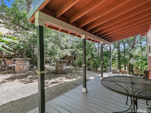 wooden terrace with a patio and an outdoor bar