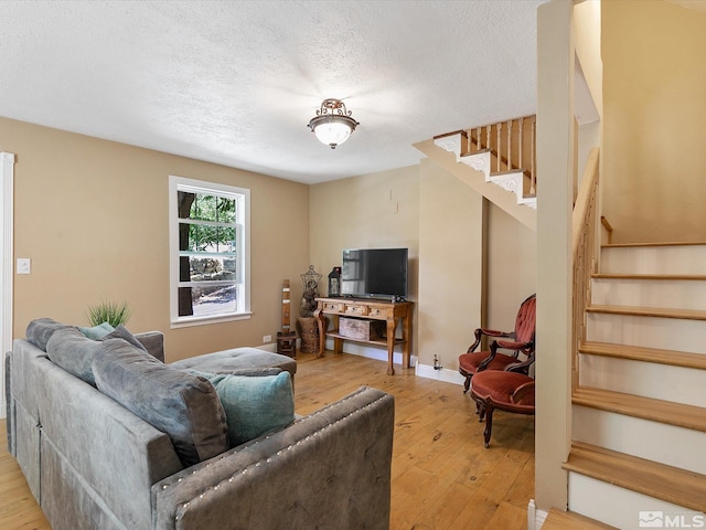 living room featuring a textured ceiling and light wood-type flooring