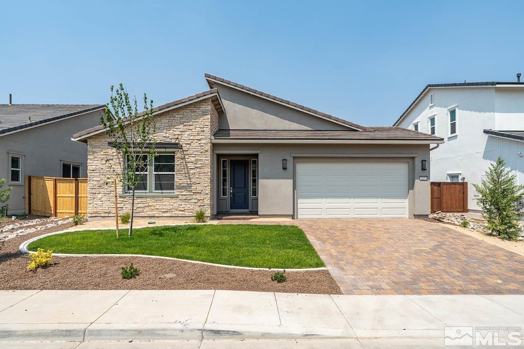 view of front of property featuring a garage and a front lawn