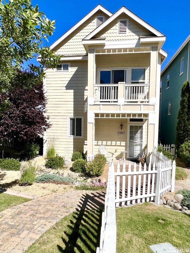 view of front of home featuring a balcony and a front yard