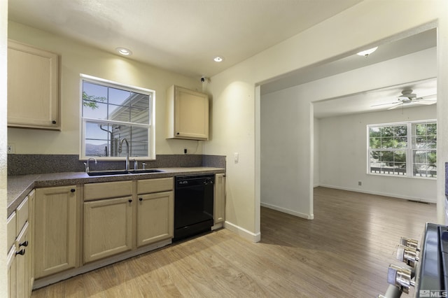 kitchen with a sink, light wood-type flooring, dark countertops, and dishwasher