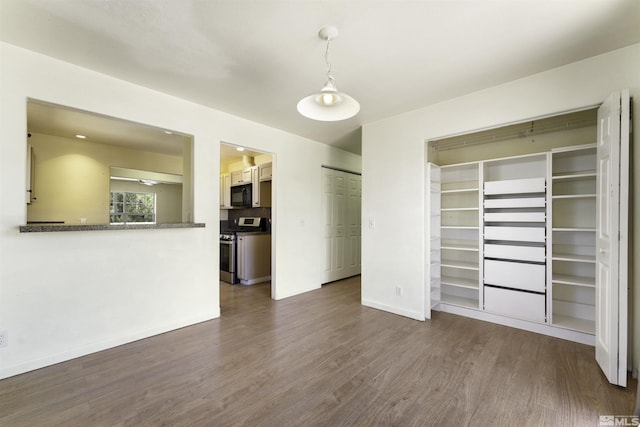 interior space featuring baseboards and dark wood-style floors