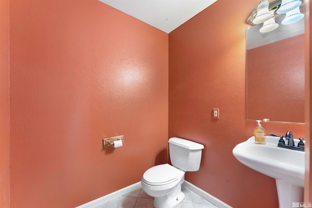 bathroom with sink, toilet, and tile patterned flooring