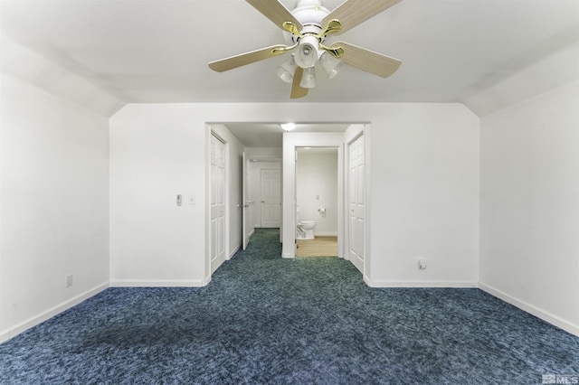 unfurnished bedroom with a ceiling fan, baseboards, vaulted ceiling, carpet flooring, and connected bathroom