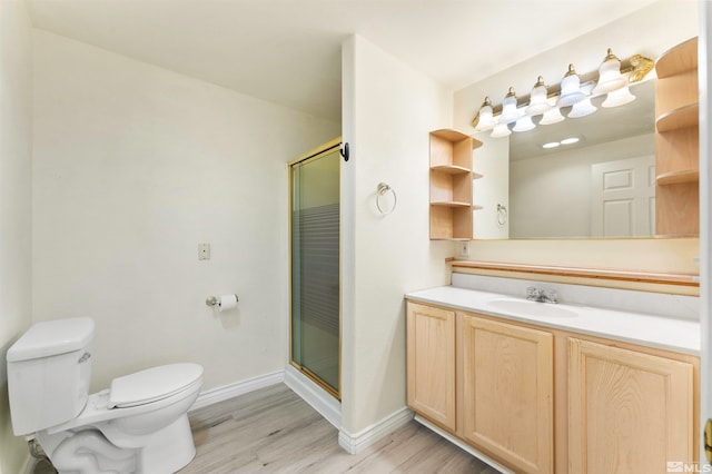 bathroom with wood-type flooring, a shower with door, toilet, and vanity