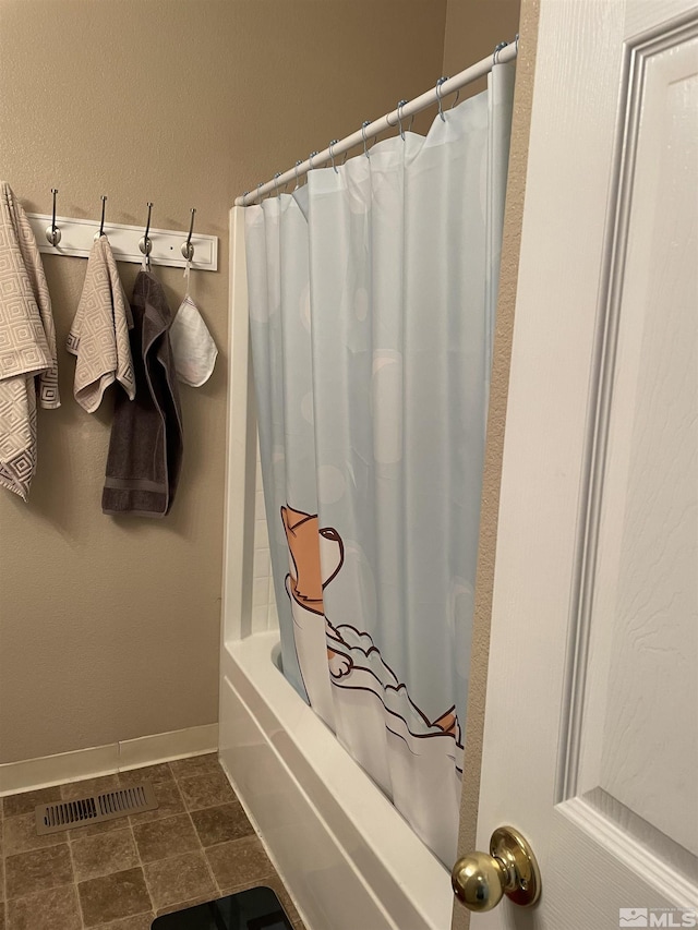 full bath with shower / tub combo, baseboards, and visible vents