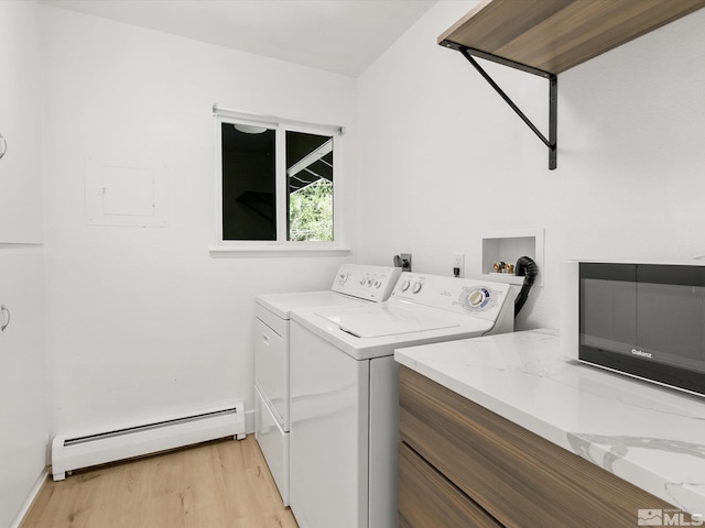 laundry room with baseboard heating, washing machine and dryer, and light hardwood / wood-style flooring