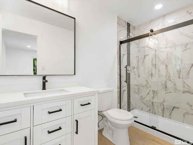 bathroom with hardwood / wood-style flooring, vanity, toilet, and an enclosed shower