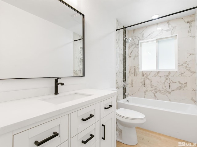 full bathroom featuring vanity, toilet, tiled shower / bath combo, and hardwood / wood-style floors