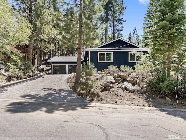 view of front of home featuring a garage and an outbuilding