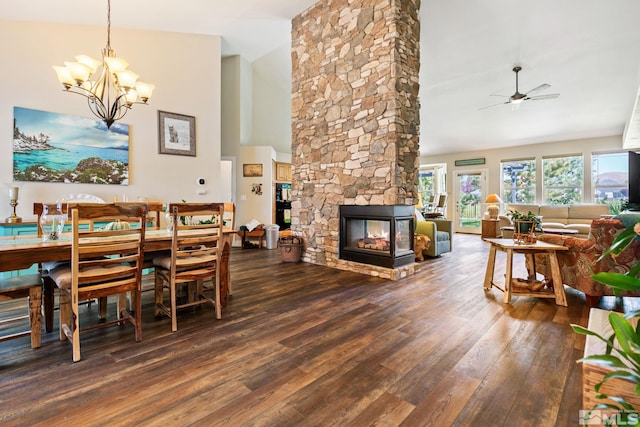 dining space featuring a fireplace, high vaulted ceiling, dark wood-style flooring, and ceiling fan with notable chandelier