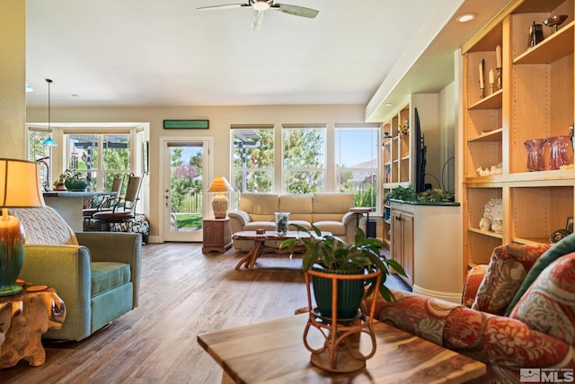 living area with light wood-style flooring and a ceiling fan