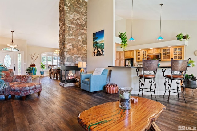 living room featuring dark wood-style floors, high vaulted ceiling, and a fireplace