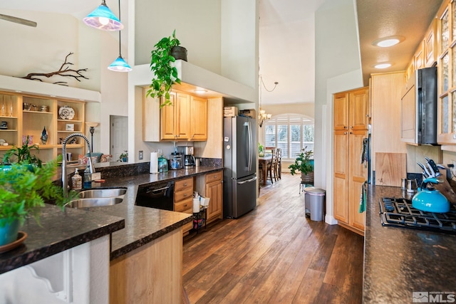 kitchen featuring pendant lighting, dark wood finished floors, freestanding refrigerator, a sink, and dishwasher