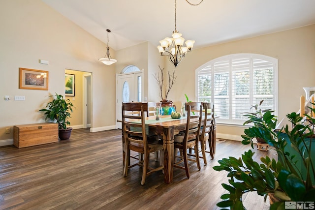 dining area featuring dark wood-style floors, high vaulted ceiling, baseboards, and an inviting chandelier