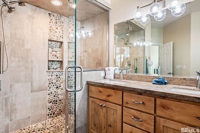 bathroom with double vanity, a stall shower, and a sink