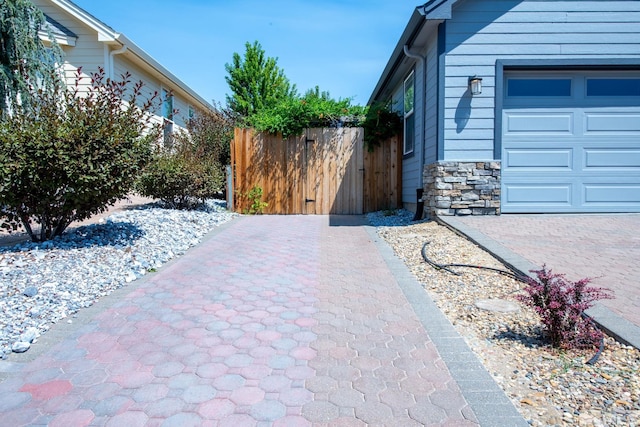 view of property exterior featuring stone siding and fence