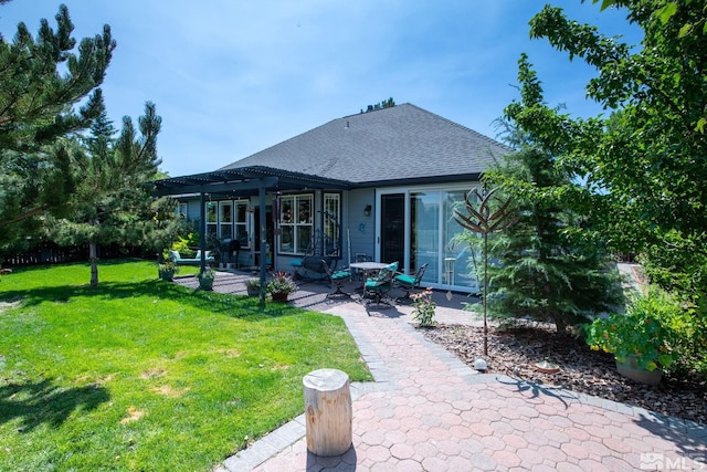 back of house with a yard, roof with shingles, a patio area, and a pergola