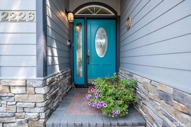 property entrance with stone siding