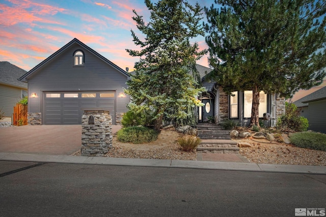 view of front of property featuring an attached garage, stone siding, and decorative driveway