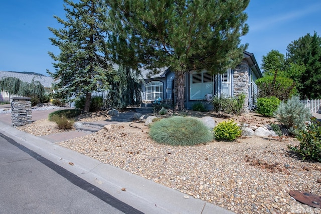 view of property hidden behind natural elements with stone siding and a mountain view