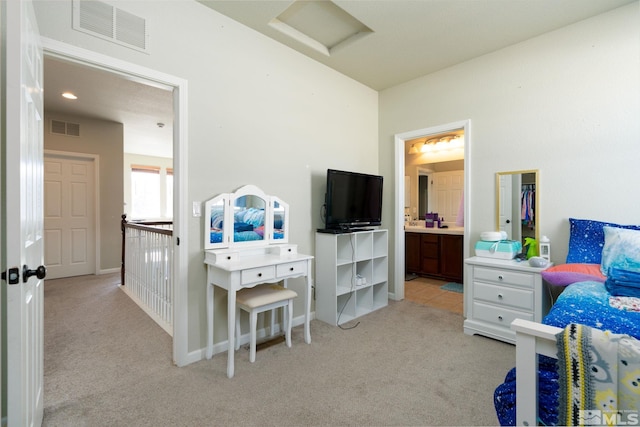 bedroom with light carpet and ensuite bath