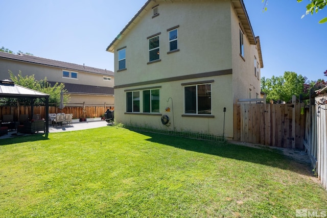 rear view of property with a yard, a patio area, and a gazebo