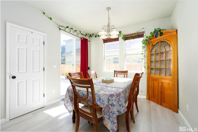 dining room with light hardwood / wood-style flooring and a notable chandelier