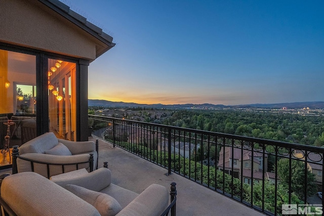 balcony at dusk featuring a mountain view