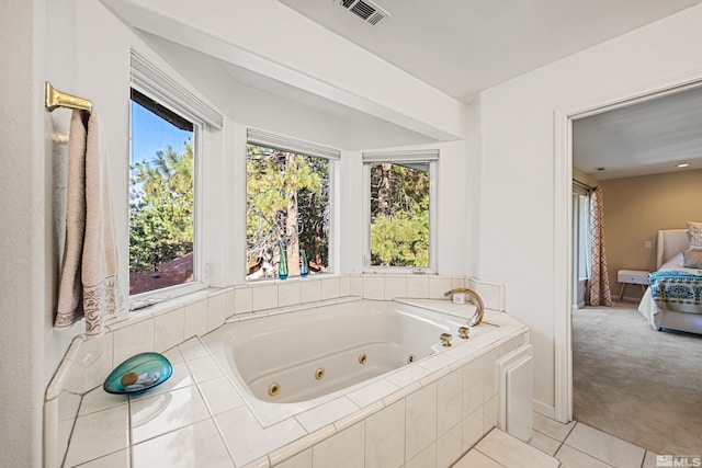 bathroom featuring a healthy amount of sunlight, a relaxing tiled tub, and tile patterned floors