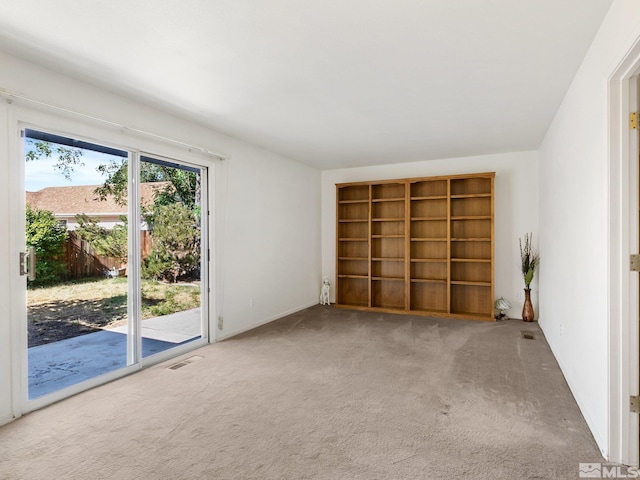 carpeted spare room featuring visible vents